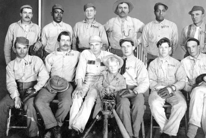 A group of inmates in uniforms pose together in 1910. Their death sentences delayed as long as they kept winning games.